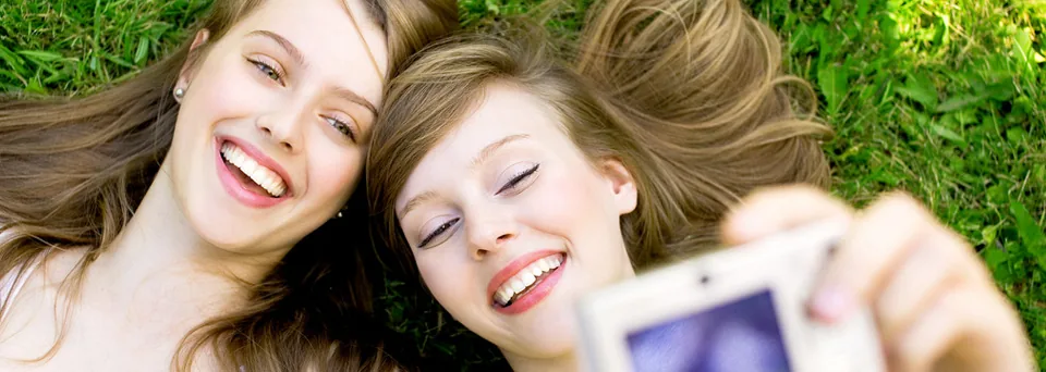 Two friends laughing together on the grass